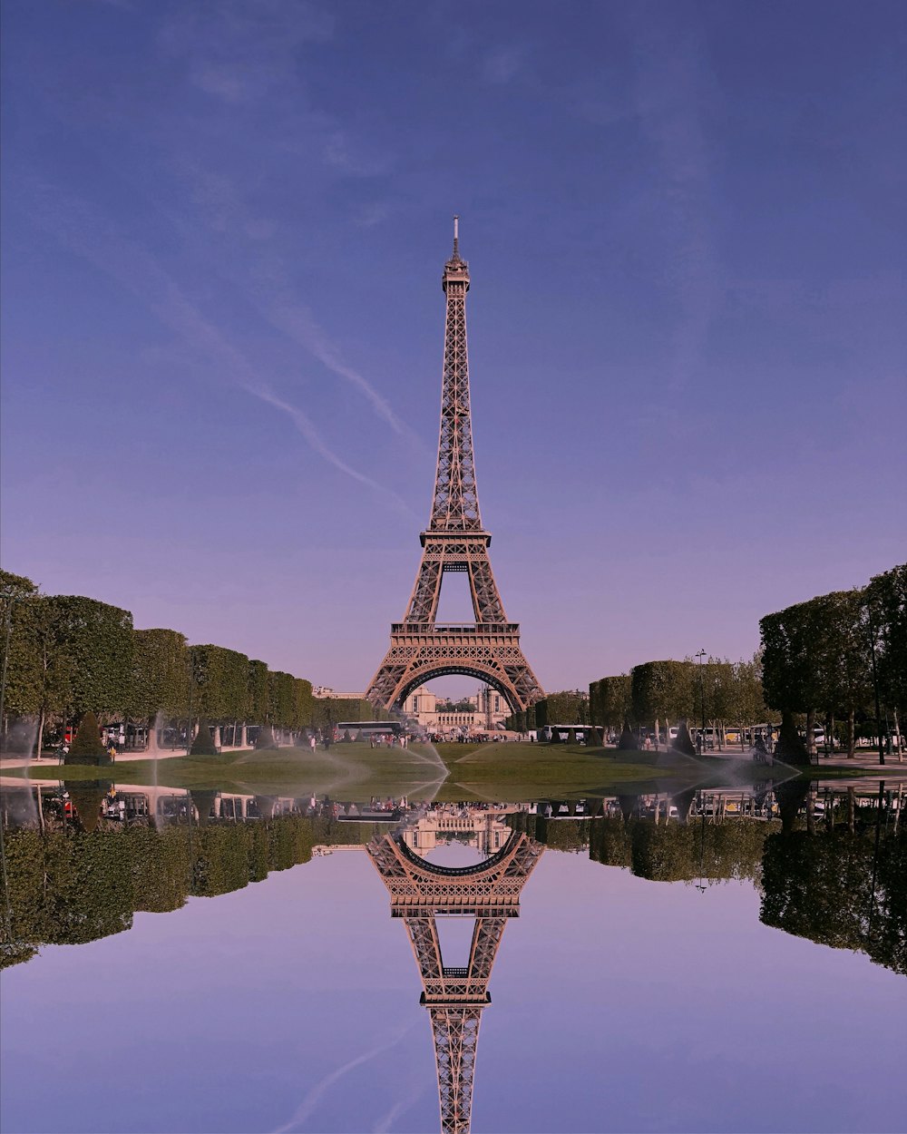 Torre Eiffel refletida na água sob um céu lilás