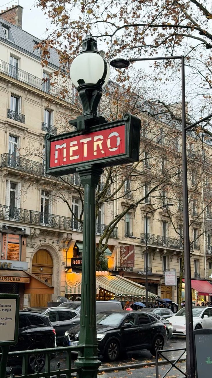 Placa vermelha do metrô de Paris numa avenida parisiense